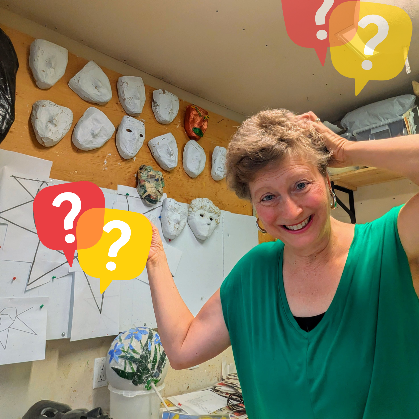 L'artiste Isabelle Roy dans son atelier entourée de ses sculptures de masques en papier mâché